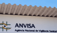 Frascos de medicamento para hipertensão com logo da Anvisa ao fundo, representando suspensão por contaminação