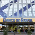 Fachada do Banco do Brasil com texto sobre calote de R$ 3,6 bilhões e inadimplência em alta