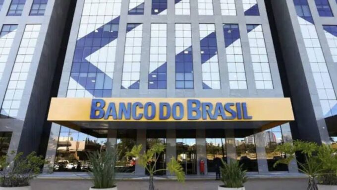Fachada do Banco do Brasil com texto sobre calote de R$ 3,6 bilhões e inadimplência em alta