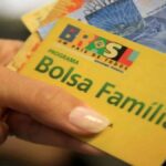 Cartao do Bolsa Familia em destaque diante de predio do Governo Federal